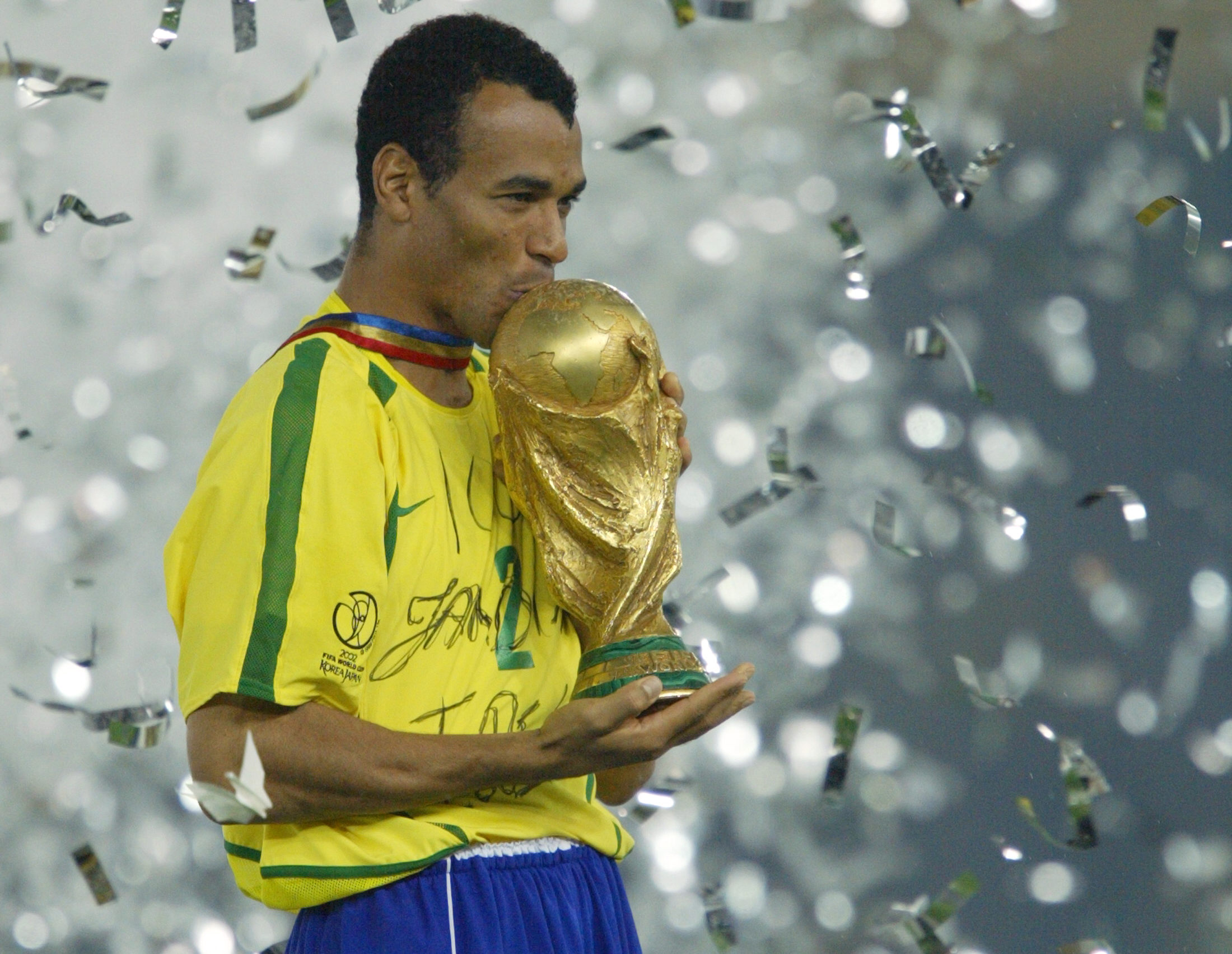 Brazil captain Cafu kisses the World Cup trophy after victory in the 2002 final against Germany.