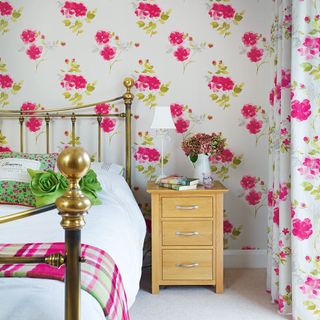 floral bedroom wallpaper with bed with cushions drawer sidetable and flower vase
