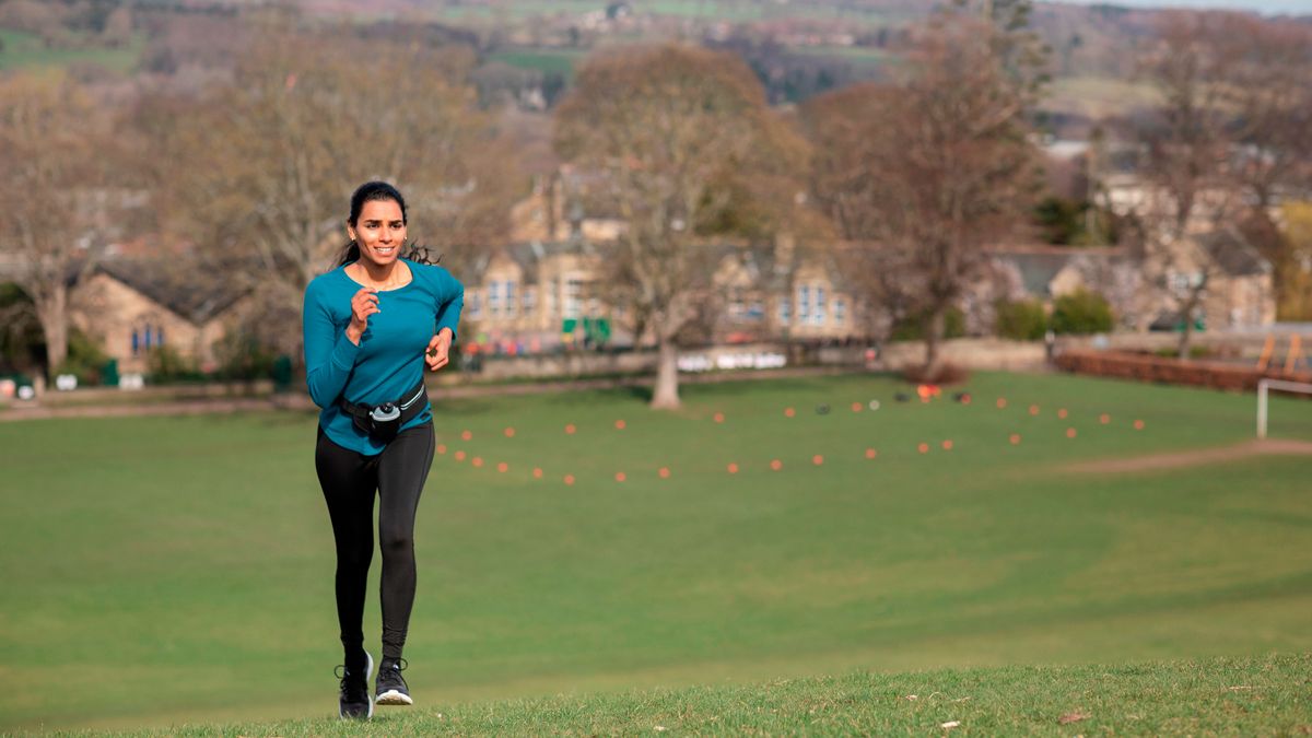 Woman running up a hill in a park