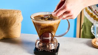 the clever dripper, a brown transparent plastic manual coffee maker with a handle and a sluice feature in the bottom to keep water inside