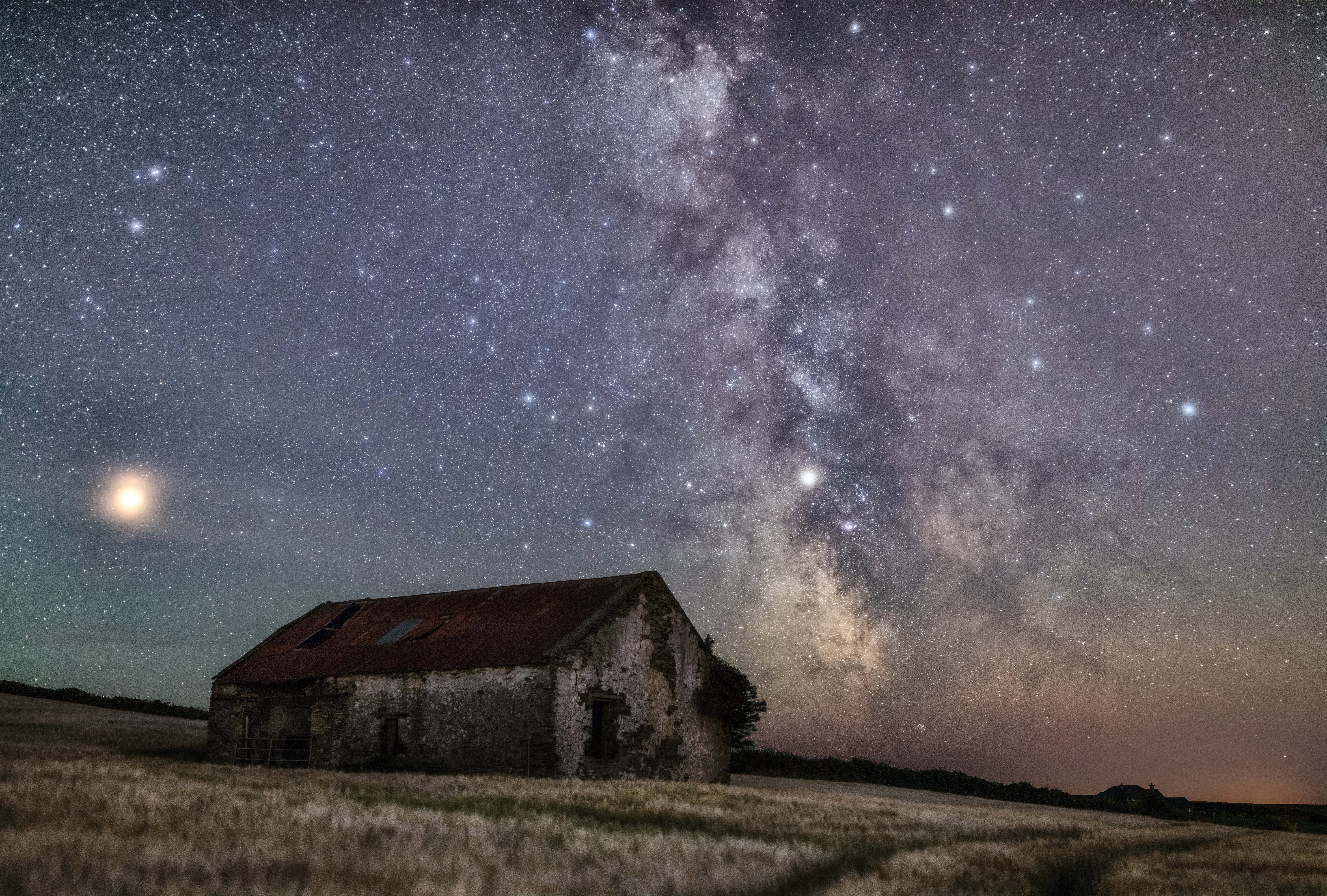 Milky Way over an old barn at night in Ireland