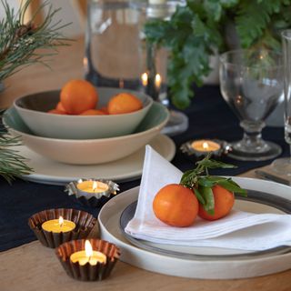 Oranges on plates on decorated dining table