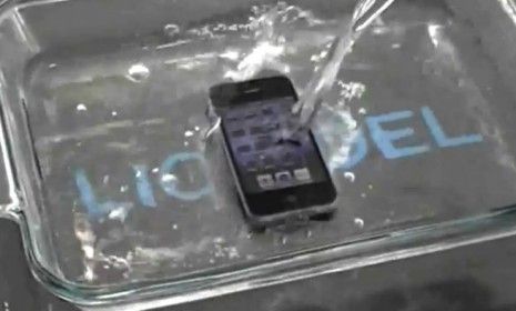 An iPhone 4 gets submerged in water and survives thanks to a thin, water-resistant coating that keeps all the electronics safe.