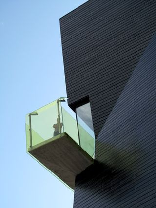 A balcony with green glass
