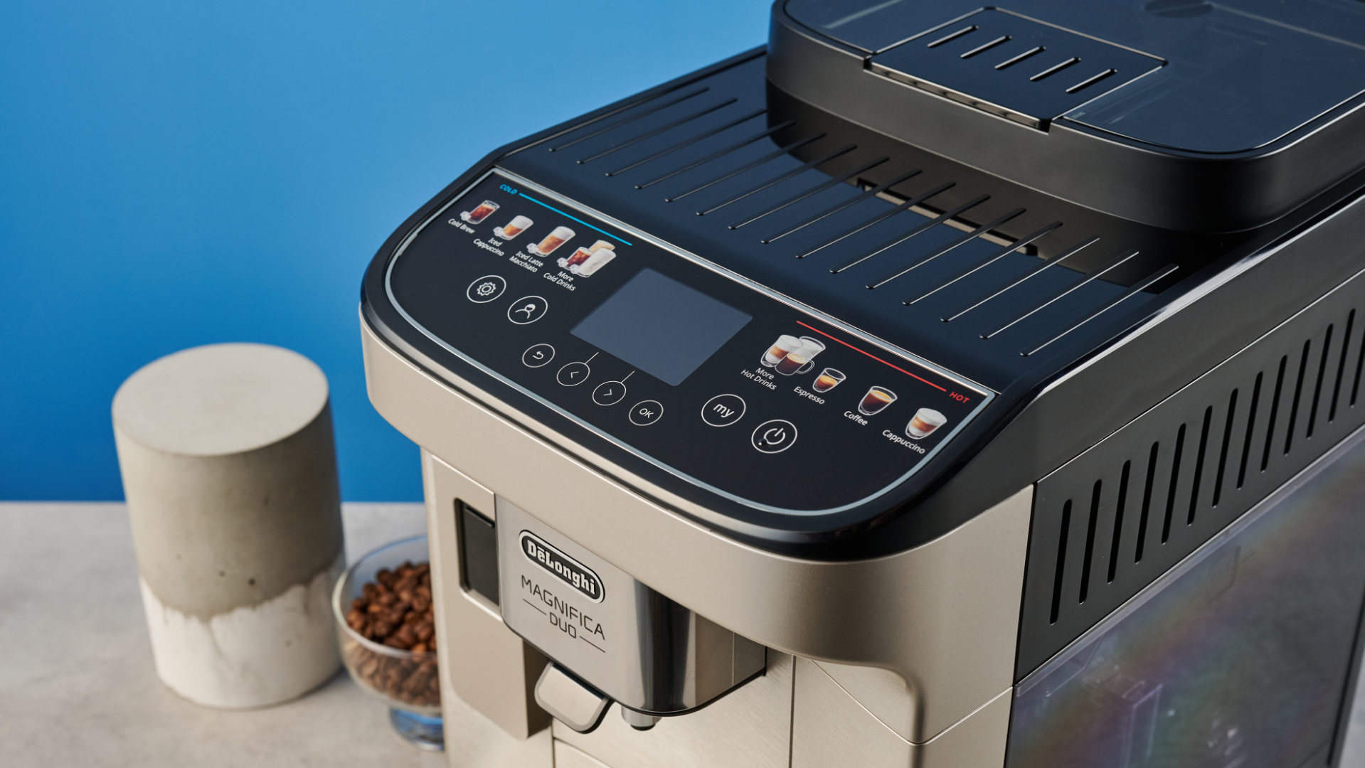 the de'longhi magnifica duo photographed with the blue tom's guide background showing the milk carafe and coffee machine screen