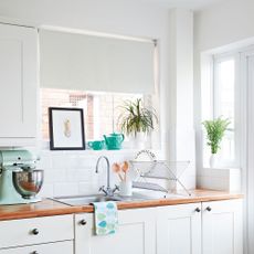 White kitchen with roller blind over the sink