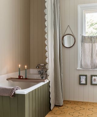 bathroom with tongue and groove bath panelling, long shower curtain with scalloped edge and cafe style curtain at window
