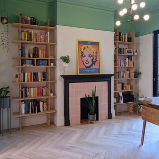 living room to home office after makeover white and green wall wooden book shelf frame on wall