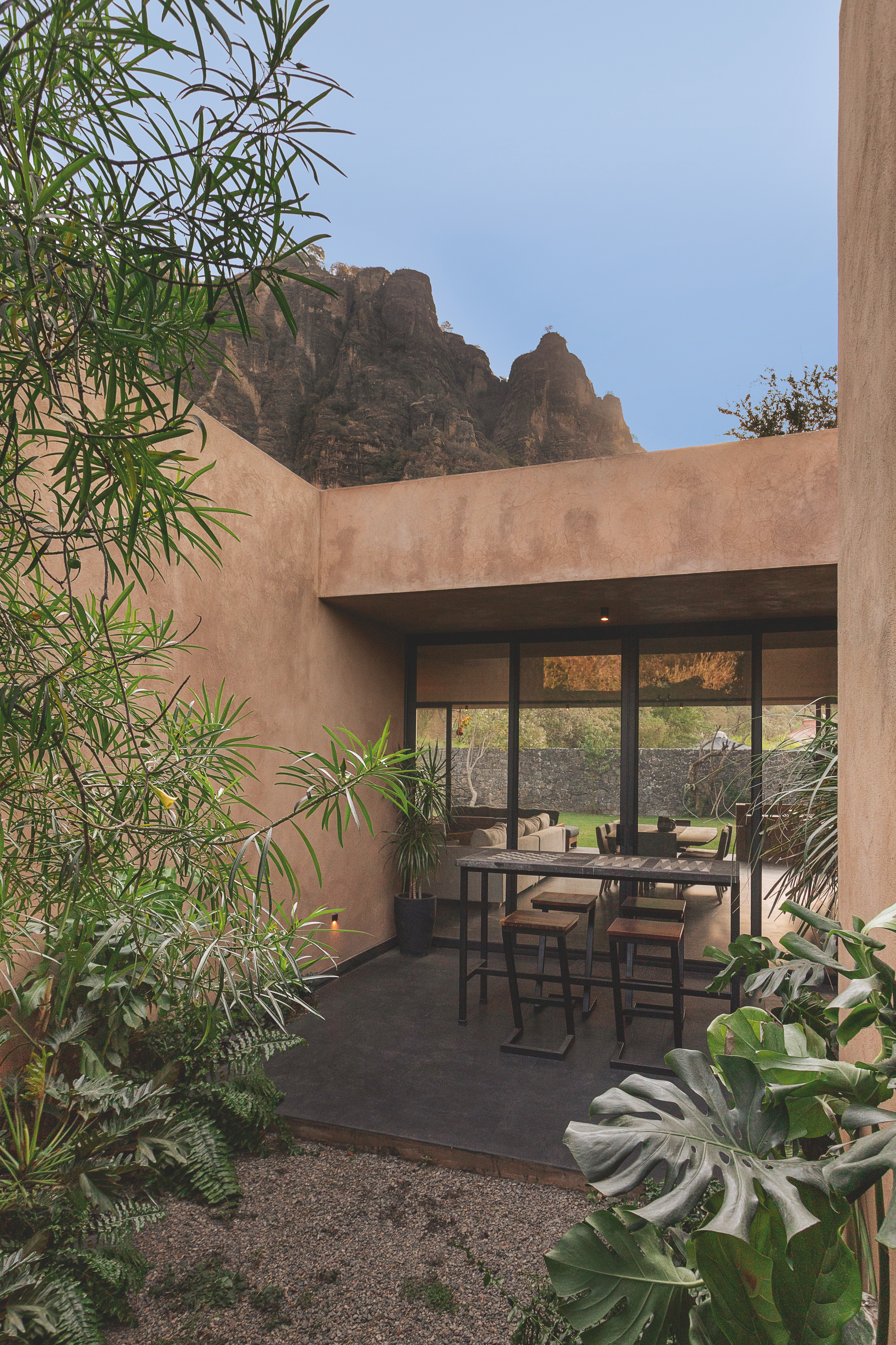 A bistro style seating area in the open courtyard, with a view into the property through glass doors on the patio.