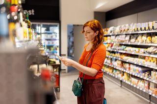 Red-haired woman browsing the aisles in a supermarket