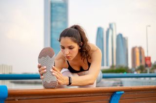 A female runner stretching her leg on a bench