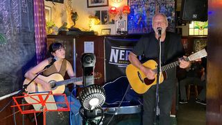 David Gilmour and Romany Gilmour playing acoustic guitar at a British pub