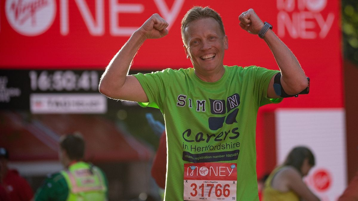 A competitor at the finish line after completing The 2021 Virgin Money London Marathon, Sunday 3rd October 2021.