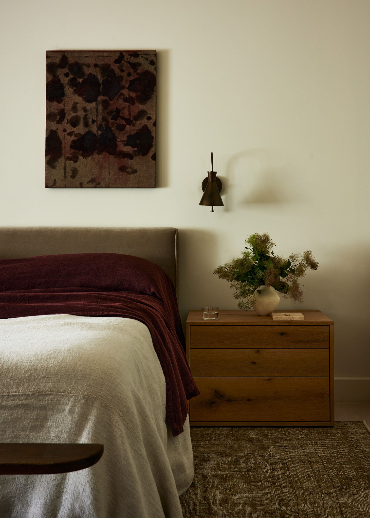 a minimalist bedroom with a red velvet bedding