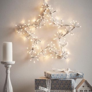Star light on the wall, on top of a candle and wrapped presents