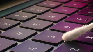 Cleaning a keyboard with a cotton bud