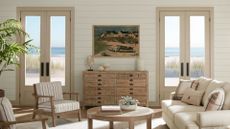 A coastal sitting room with neutral couch, chairs and coffee table in pale wood, the walls are panelled and painted in Sherwin Williams Shiitake