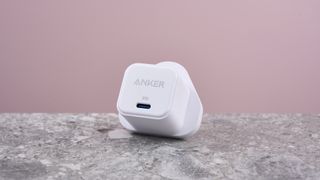 Anker PowerPort III 20W balanced on stone surface showing USB-C port