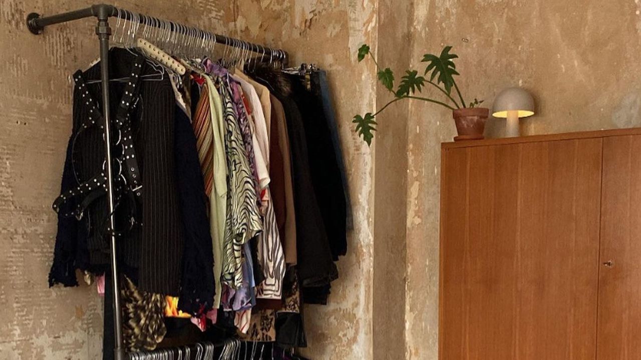 Clothing rack in a bedroom with a wooden wardrobe