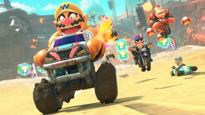 Mario Kart World screenshot for Switch 2 showing Wario blasting ahead with a host of characters right behind him in a desert biome