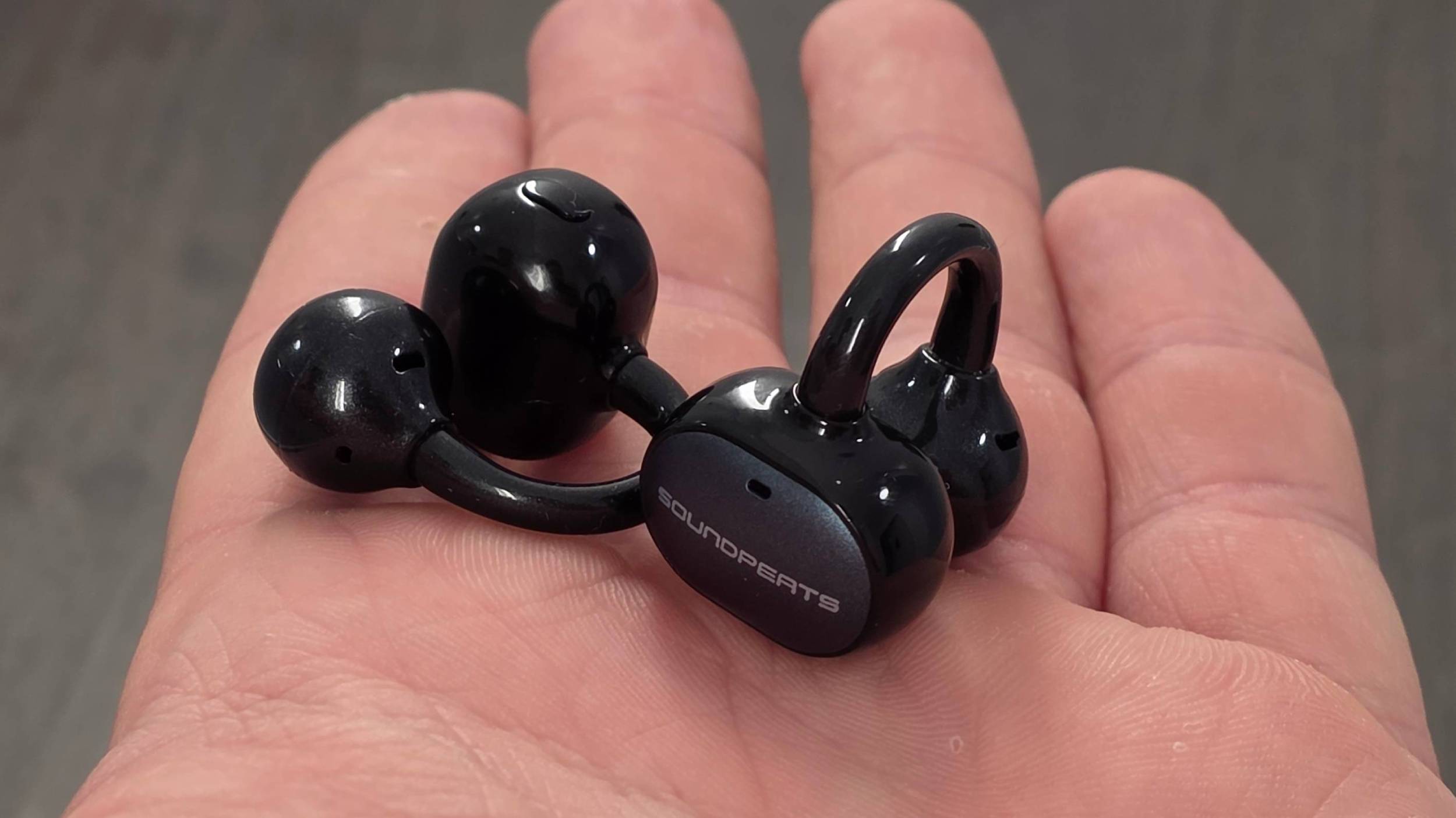 The Soundpeats Pop Clip2 in a man's hand.