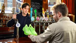 Person receiving Asics running shoes from barman in pub