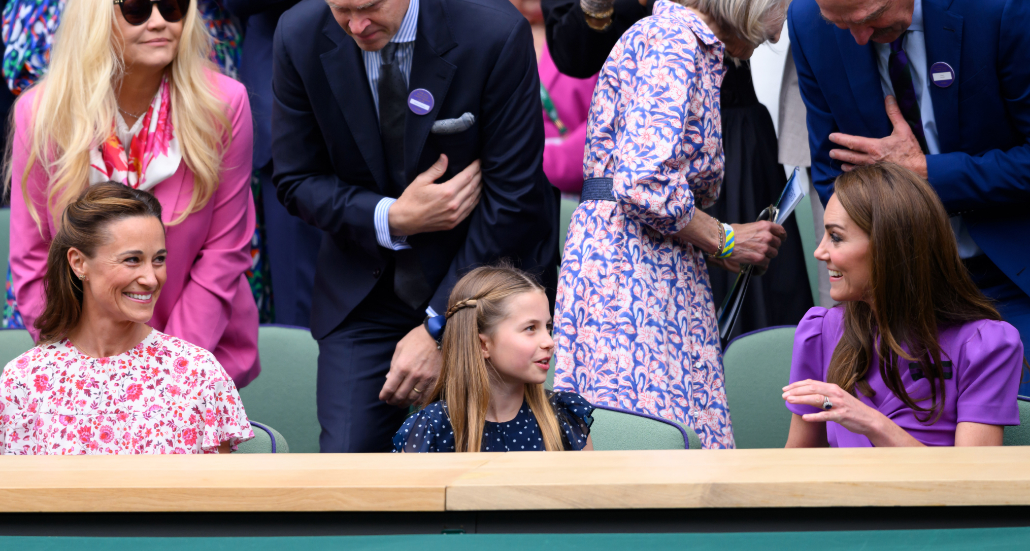 Pippa Middleton, Princess Charlotte and Princess Kate sitting down and smiling at each other at Wimbledon 