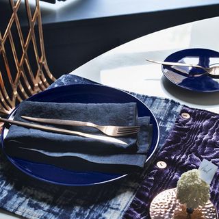 dining table with bleu de four dinner plate knife fork and napkin