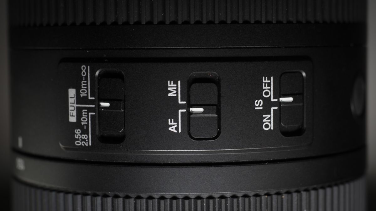 OM System M.Zuiko 150-600mm f/5.0-6.3 IS lens, mounted to an OM System OM-1 Mark II, on a wooden surface lit with moody lighting
