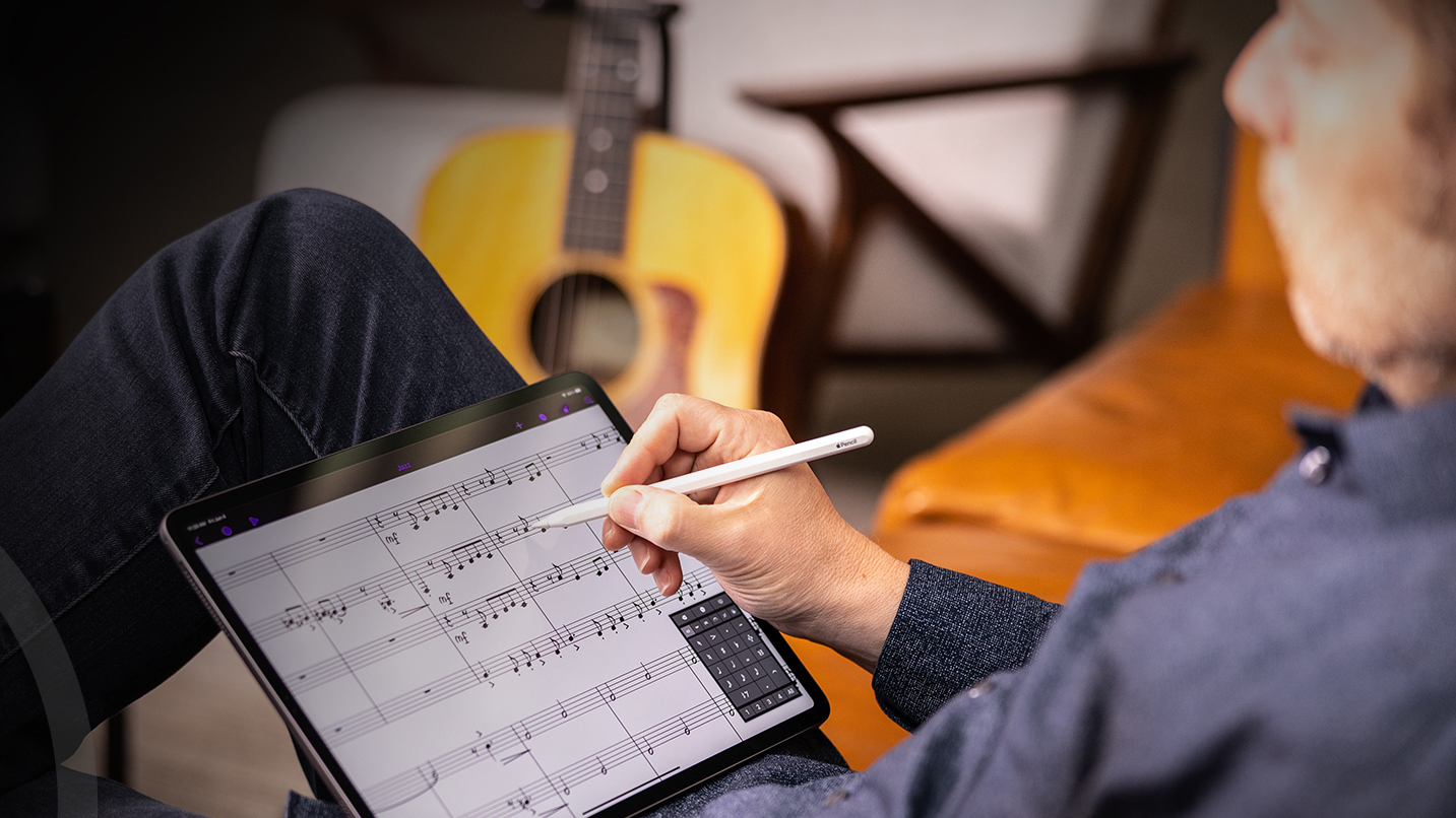 Man works on a music score on his iPad