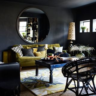 black walls with mirror on wall and sofa set with cushion