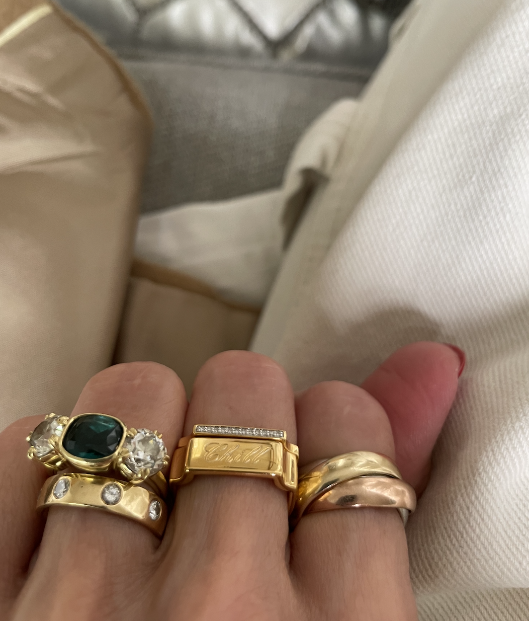 a close-up image of Larissa Mills wearing a stack of silver and gold rings