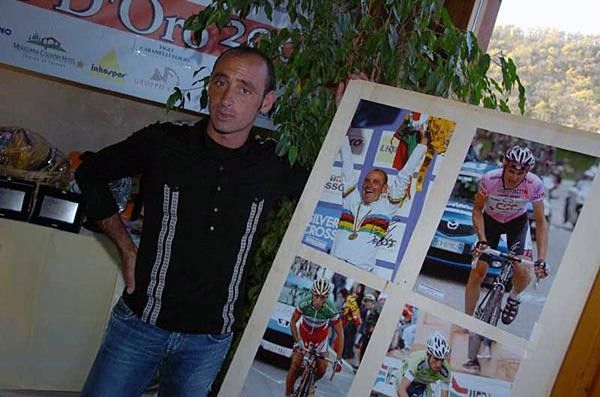 Paolo Bettini next to poster celebrating his Worlds victory