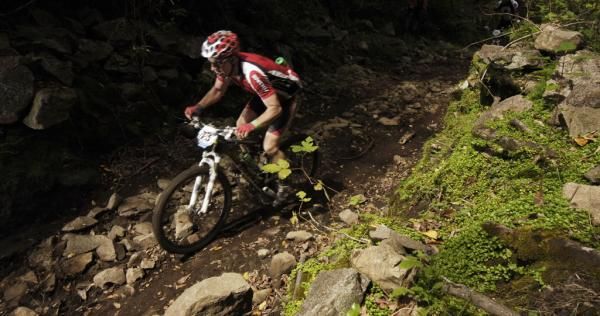 A racer on a rocky singletrack section