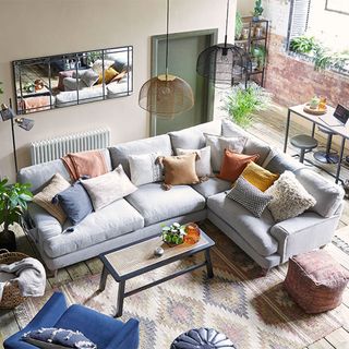 Overhead image of living room with L-shaped sofa, patterned rug and pendant lights