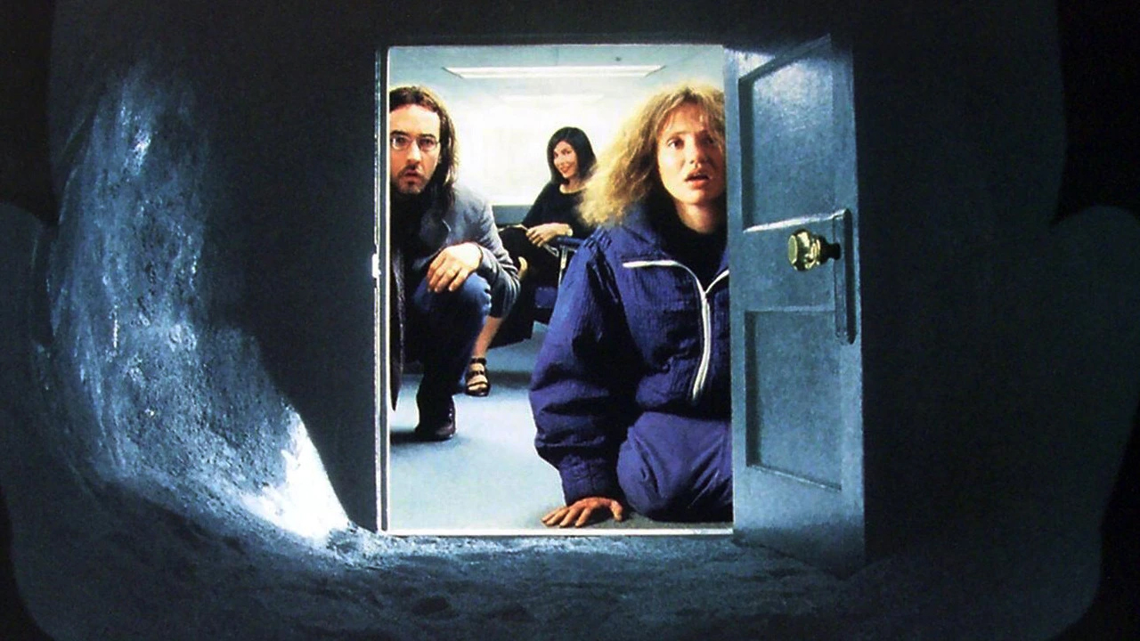 A still from Being John Malkovich in which John Cusack and Cameron Diaz look into a tunnel at the camera.