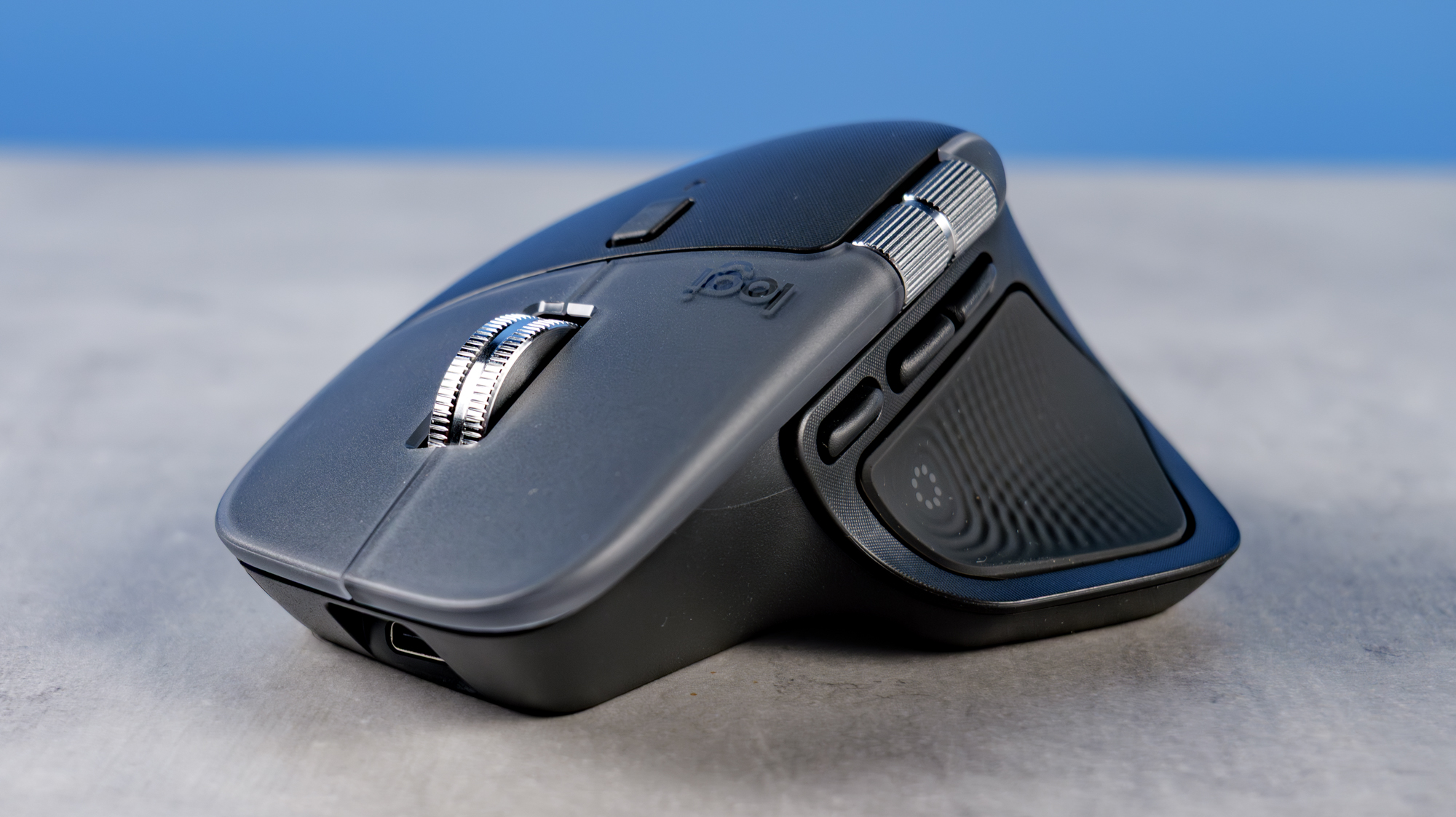 A photo of the Logitech MX Master 4 on a stone surface with a blue background