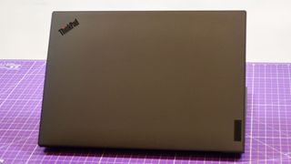 A Lenovo ThinkPad P1 Gen 6 on a table with a purple desk mat underneath