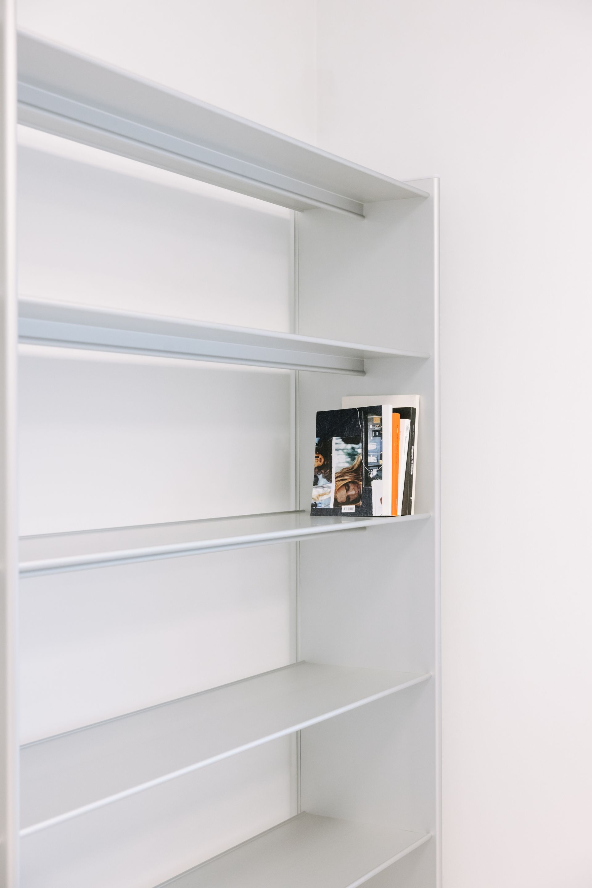 Empty metal shelves with a handful of fashion magazines