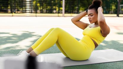 Woman completes ab workout outside