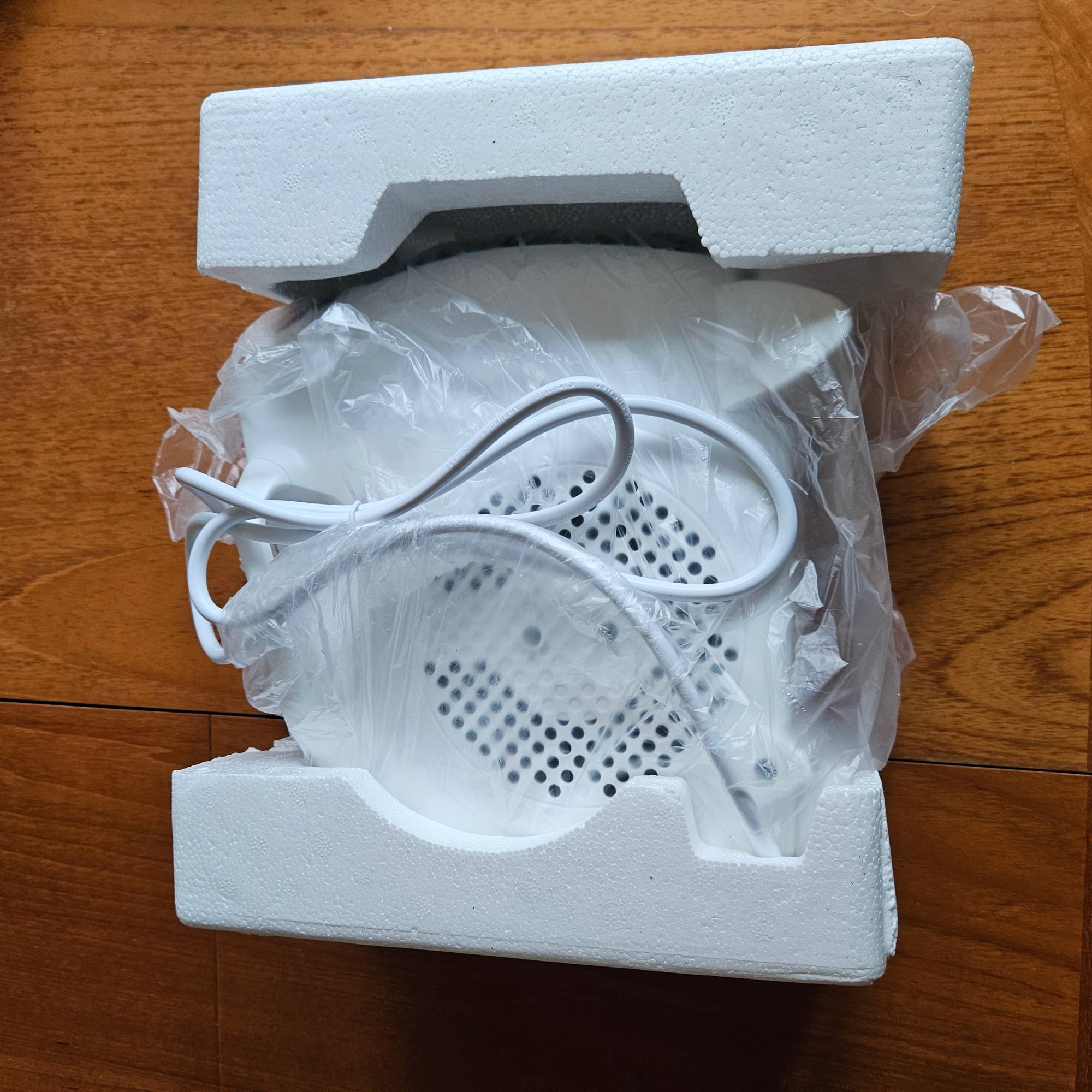 white fan heater in packaging on wood table