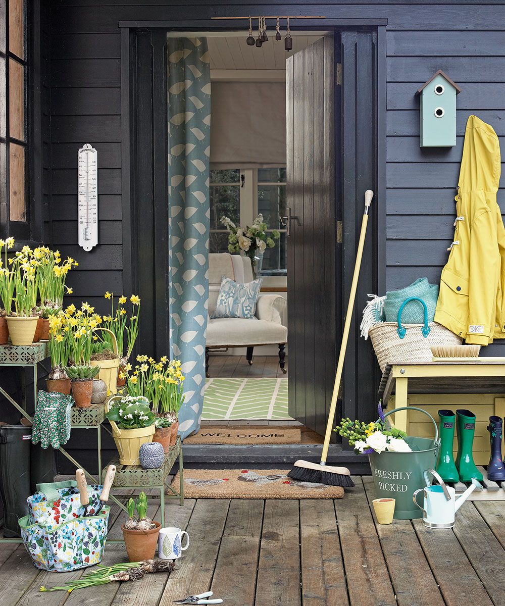 Verandah with potted plants and broom on door mat