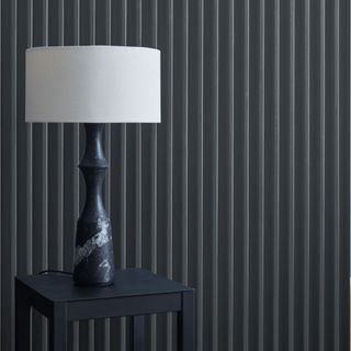 A blue-gray wall with a lamp in front