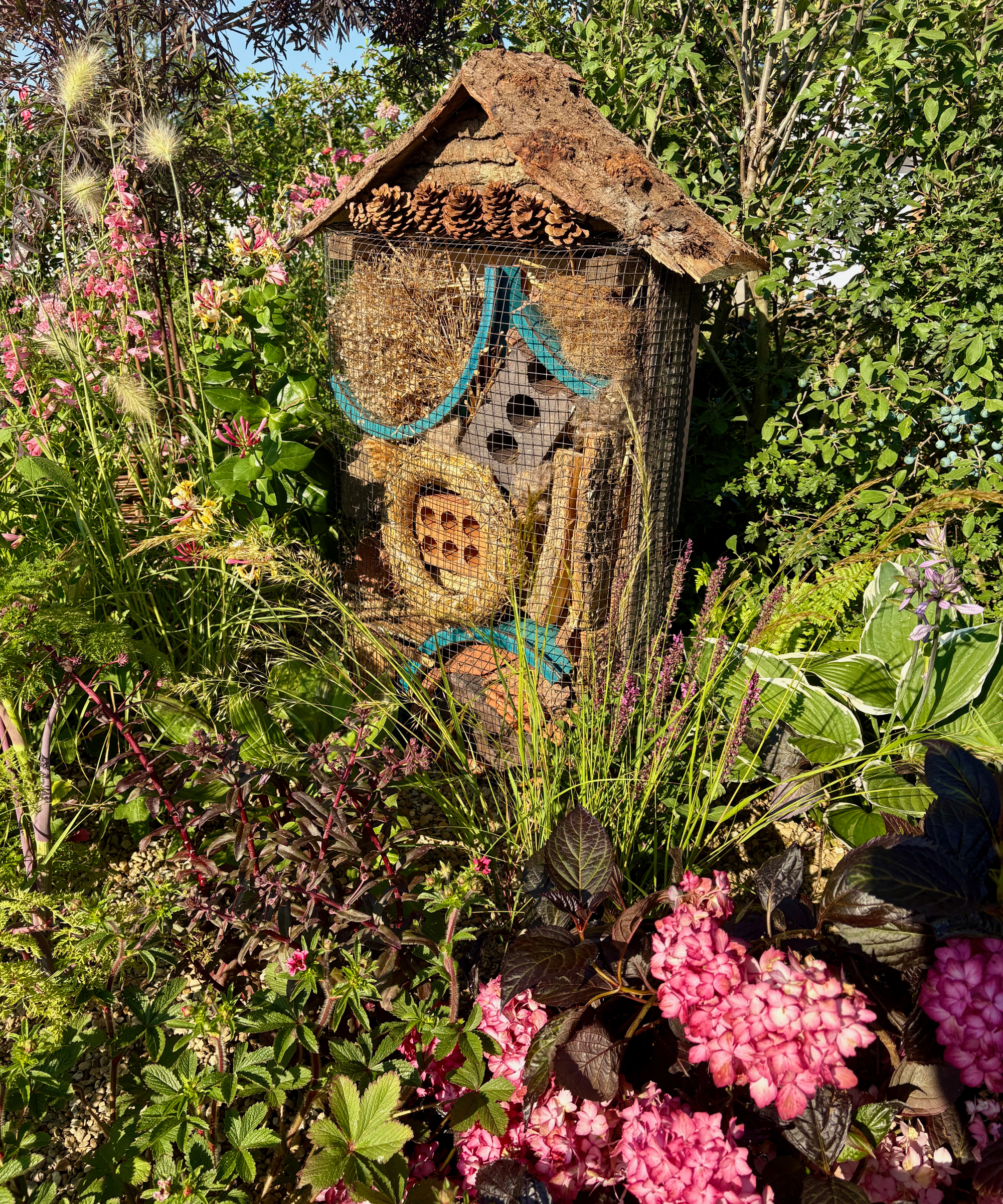 insect hotel in border of a wildlife garden