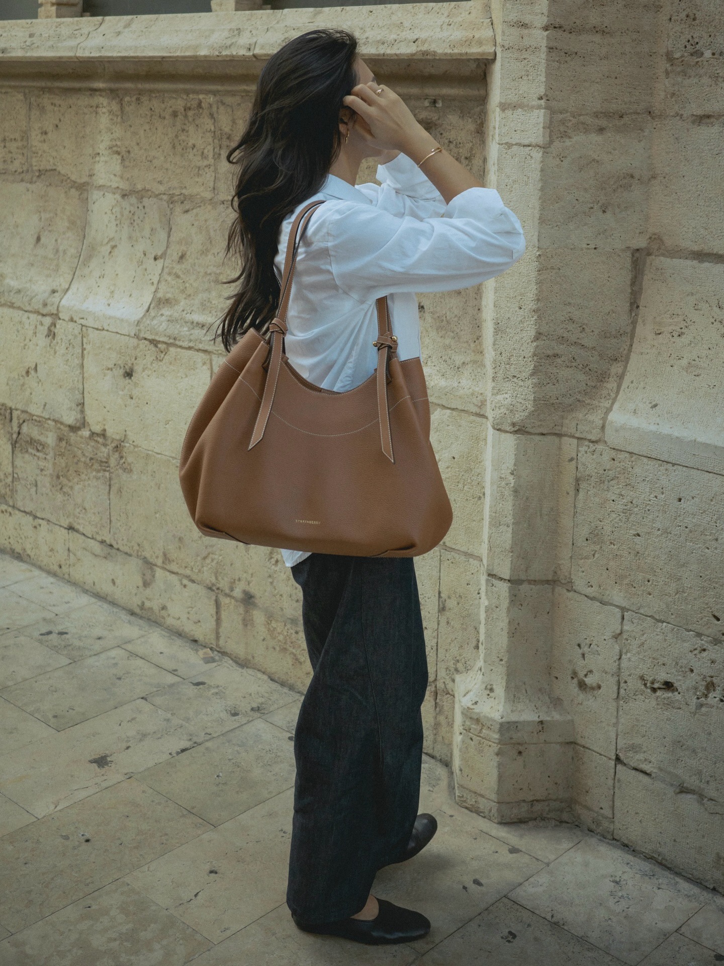 Michelle wearing the Barra tote in tan.