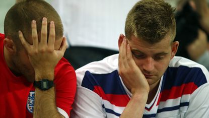 England fans look dejected after England's defeat by Uruguay 