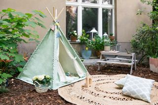 boho garden with a kids teepee and jute outdoor round rug