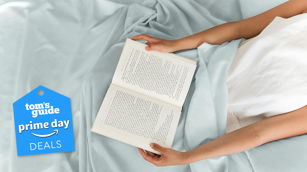 The image shows a person reading a book on a CGK aqua blue sheet with a Tom&#039;s Guide Prime Day deal badge overlaid 