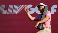 Cameron Smith waves to the crowd whilst holding a LIV Golf trophy