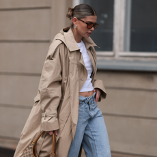 Sophia Geiss seen wearing Vehla Eyewear brown sunglasses, silver chunky earrings, Uniqlo white cotton basic cropped shirt, Levi's light blue denim / jeans pants, COS beige oversized long coat / trenchcoat, Gucci vintage brown canvas logo pattern bag and LeGer black leather loafers, on April 22, 2024 in Berlin, Germany. (